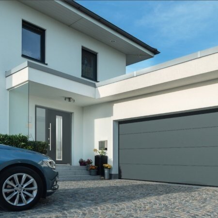 Bild von einem Haus - silbernes Auto steht vor einer geschlossenen Garage